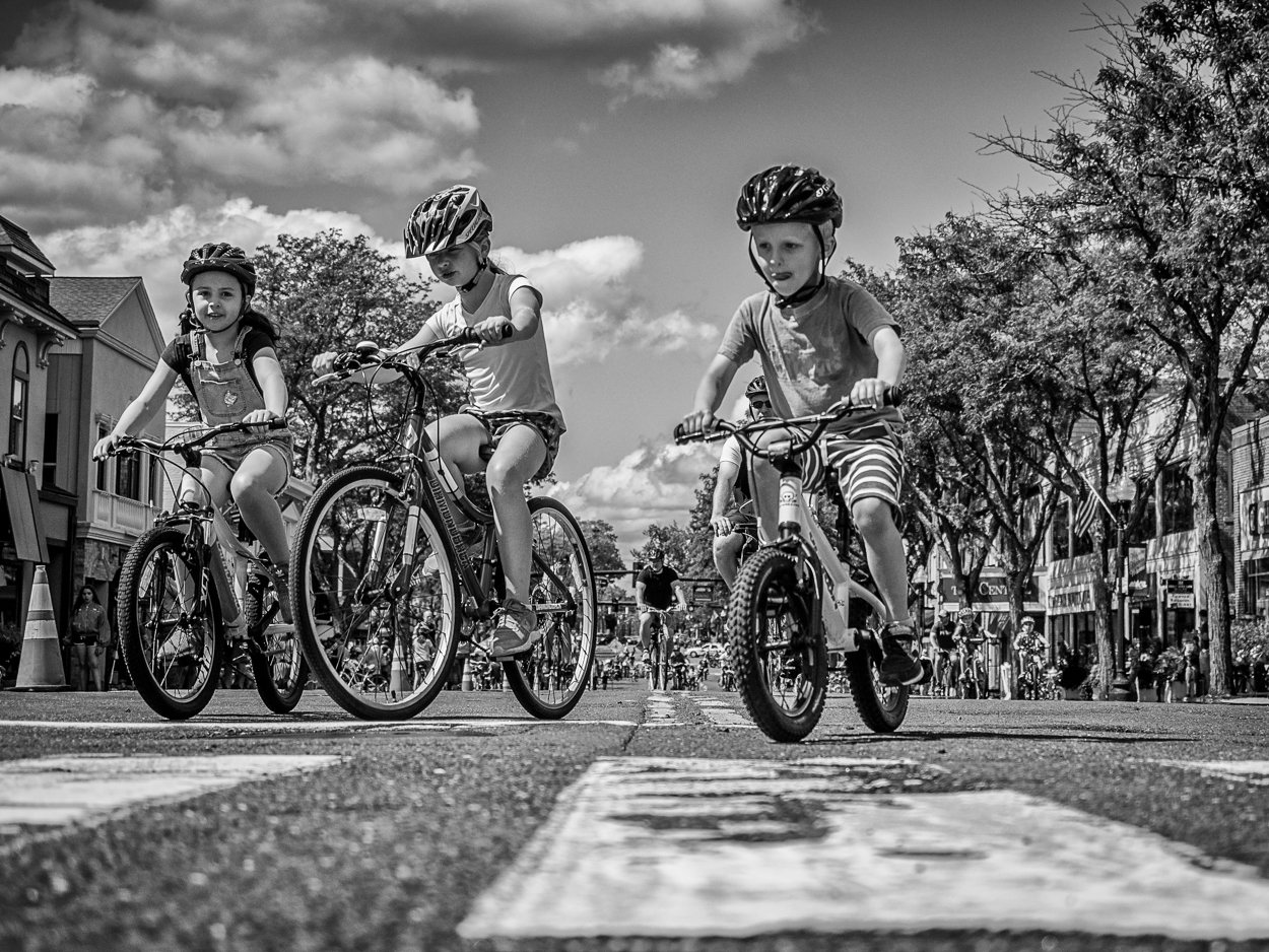 black and white photo of three children biking during a Center Streets event in West Hartford, CT