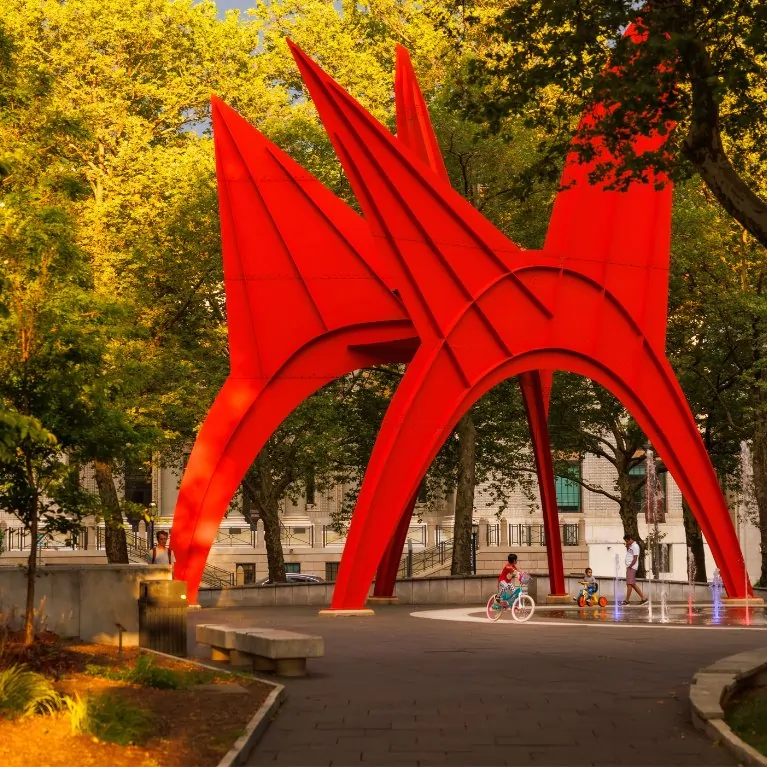 large red sculpture with kids playing underneath it in park in Hartford, Connecticut.