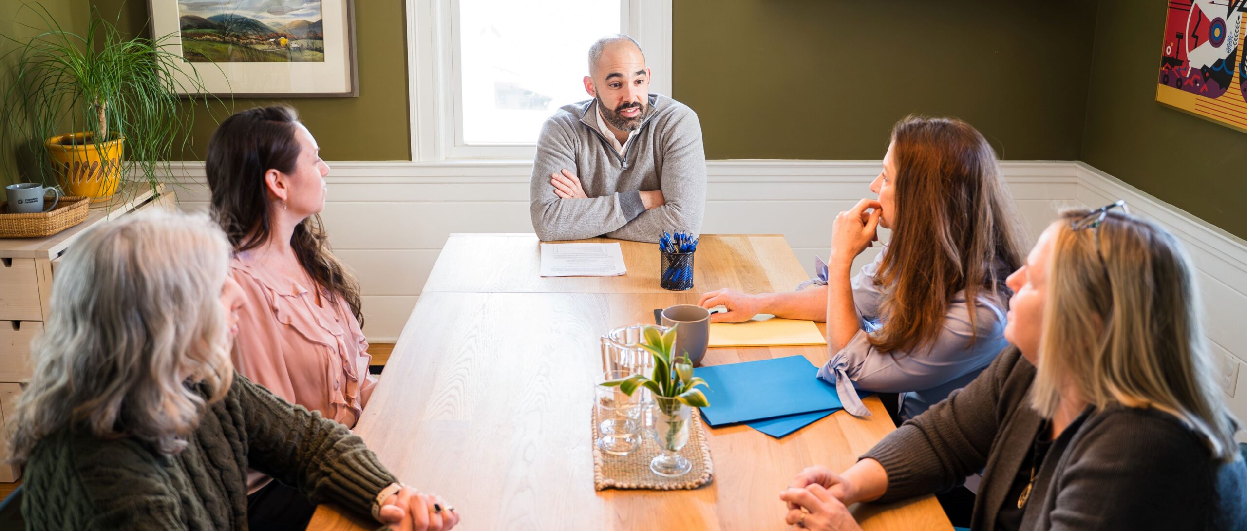 Team meeting with Attorney Aaron Frankel at the head of the table, leading discussion.